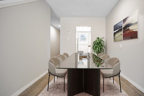 A dining room with a table and chairs.