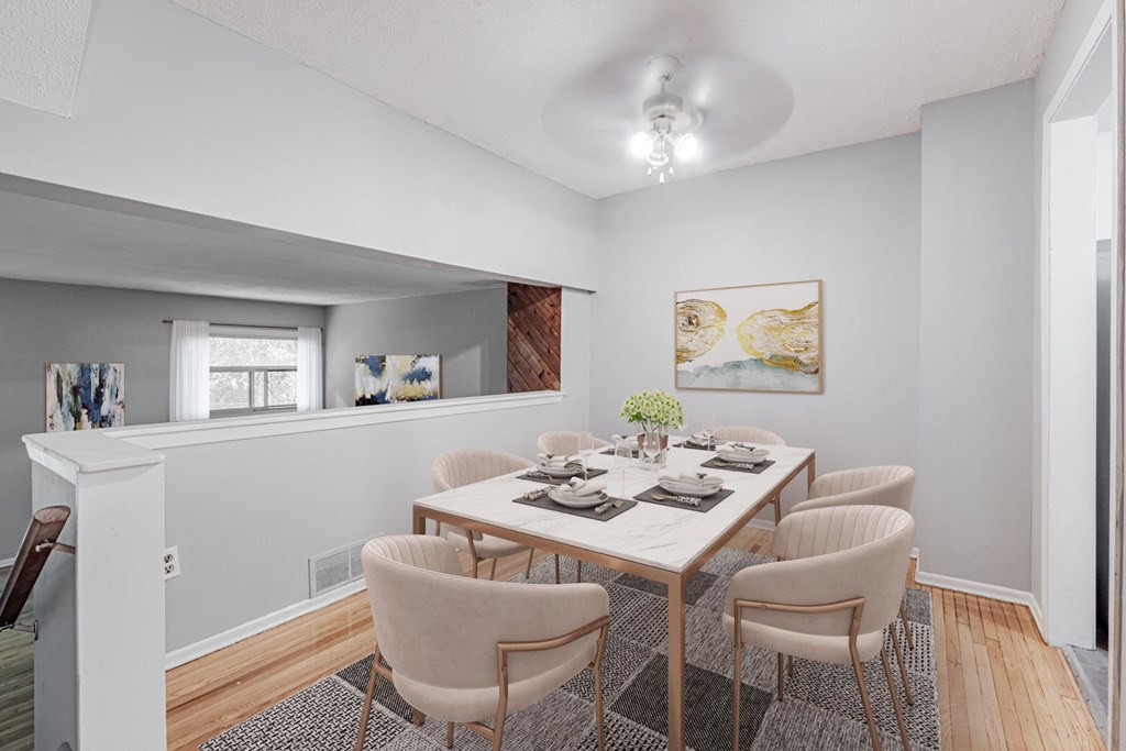 A dining room with a white table and chairs.