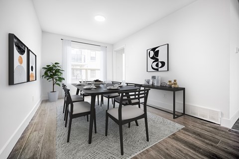 A dining room with a table and chairs.