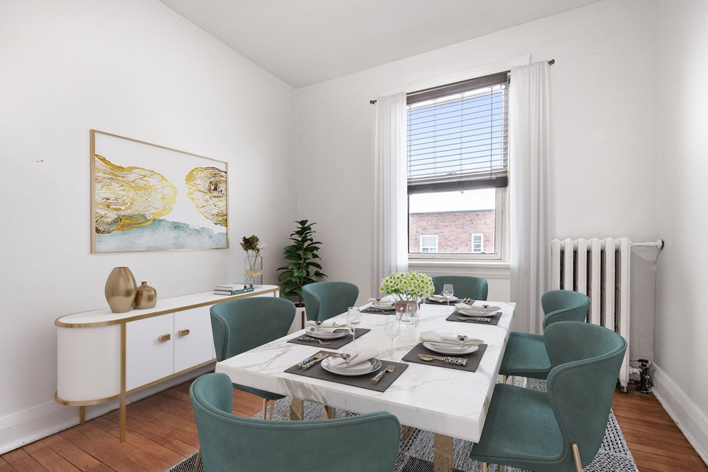 A dining room with a white table and green chairs.