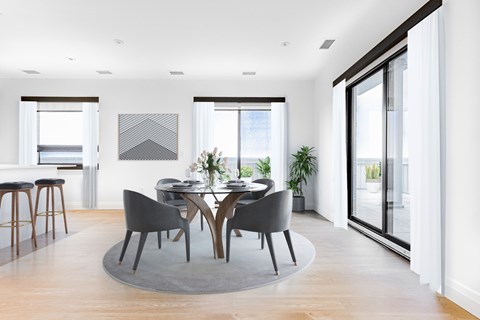 A modern dining room with a round table and chairs.