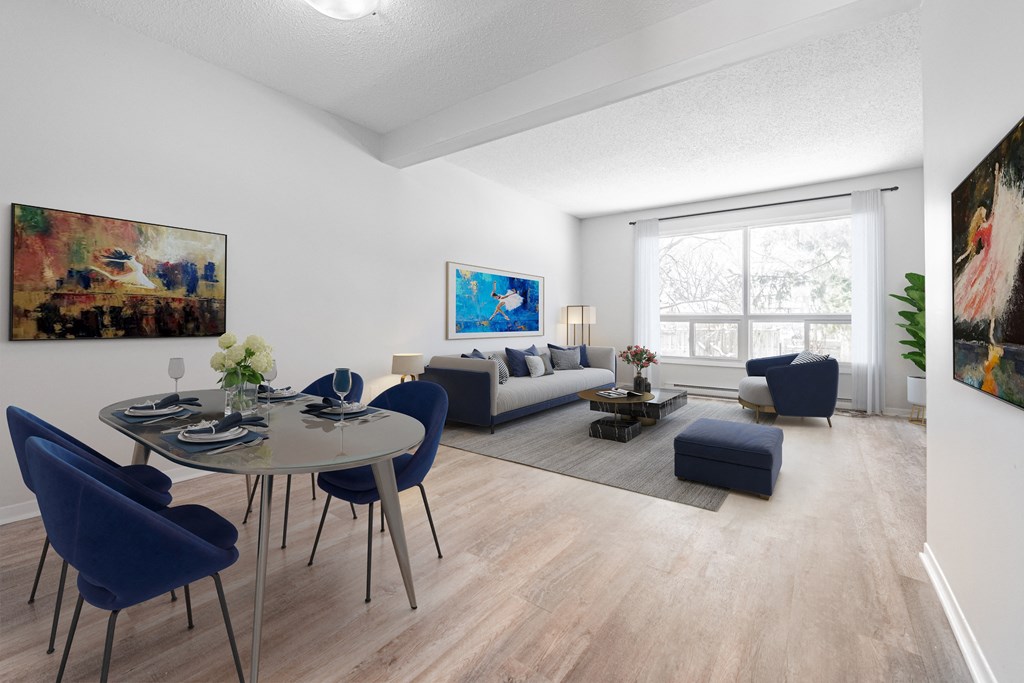 A dining room with a glass table surrounded by blue chairs.