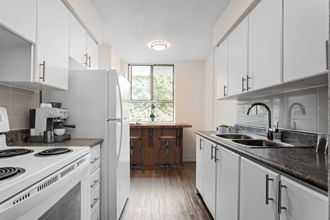A kitchen with white cabinets and a black stove top.
