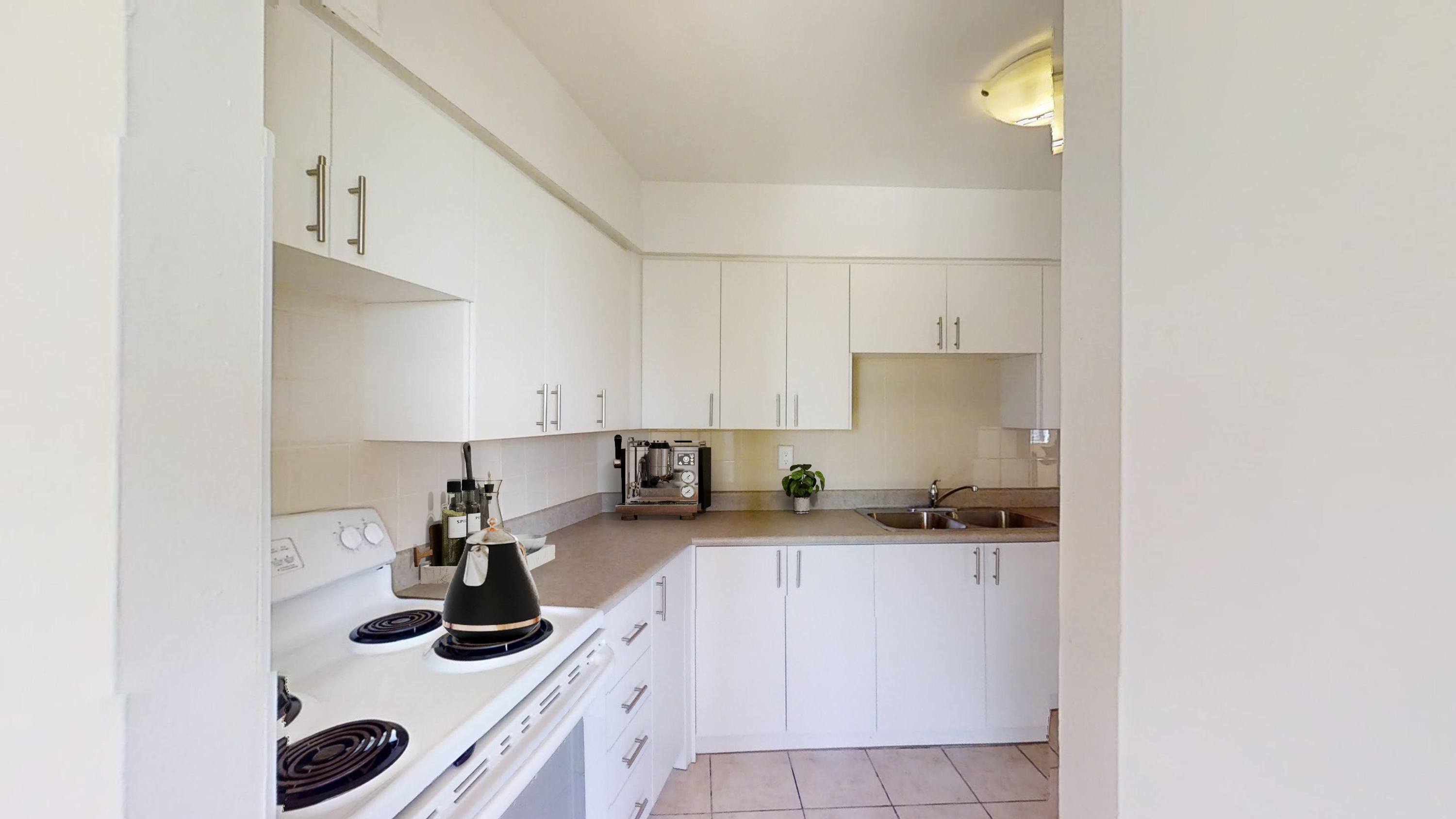A kitchen with white cabinets and a black stove top.