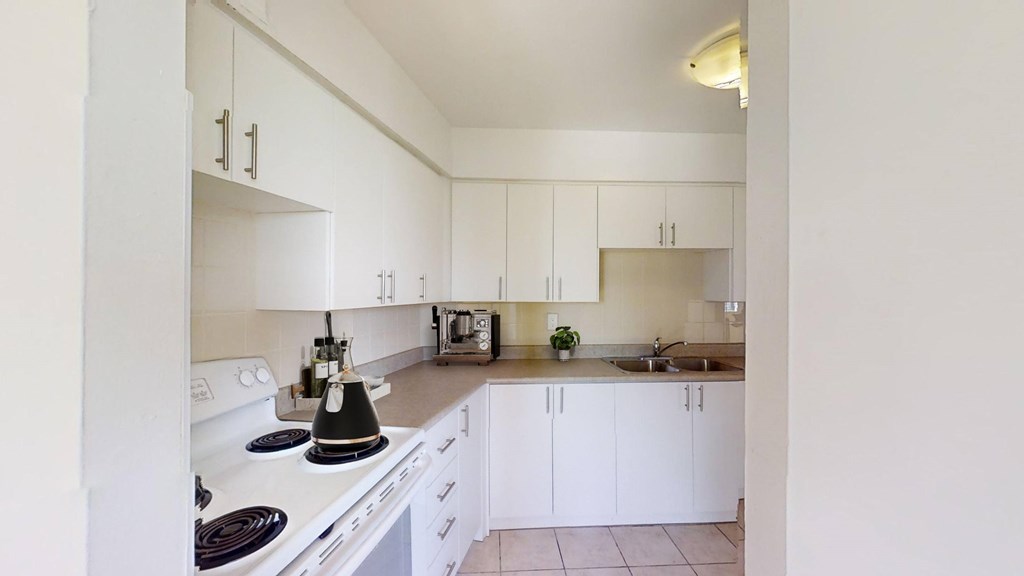 A kitchen with white cabinets and a black stove top.