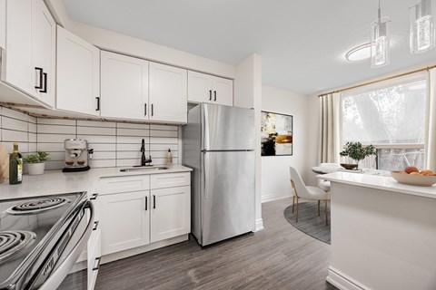 A modern kitchen with white cabinets and a stainless steel refrigerator.