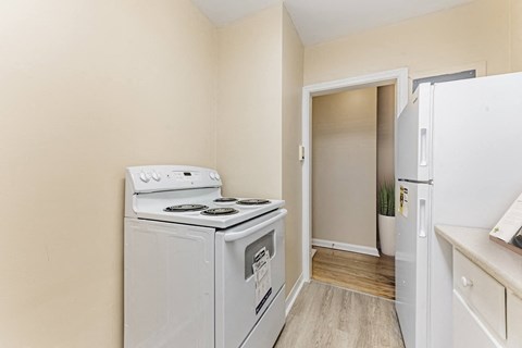 A small kitchen with a white stove and a white refrigerator.