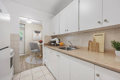 A kitchen with white cabinets and a beige countertop.