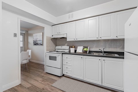 A kitchen with white cabinets and a white oven.