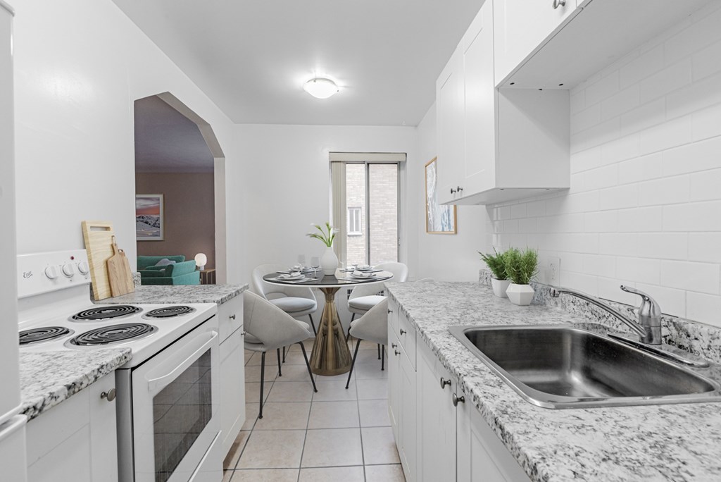 A kitchen with a table and chairs in the middle.