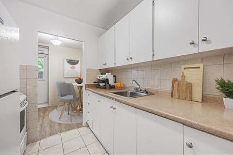 A kitchen with white cabinets and a beige countertop.