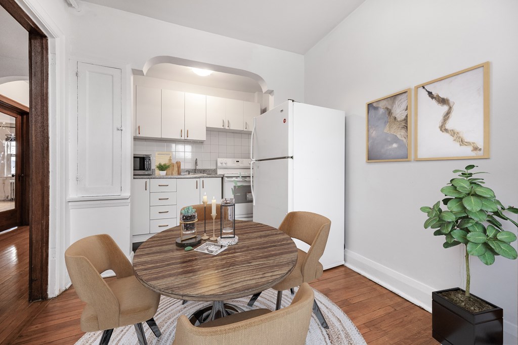 A dining room with a table and chairs.