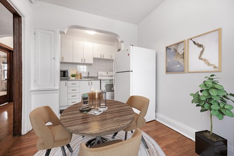 A dining room with a table and chairs.