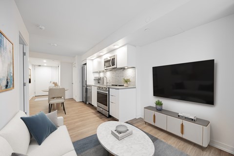 A modern living room with a television, a couch, and a coffee table.