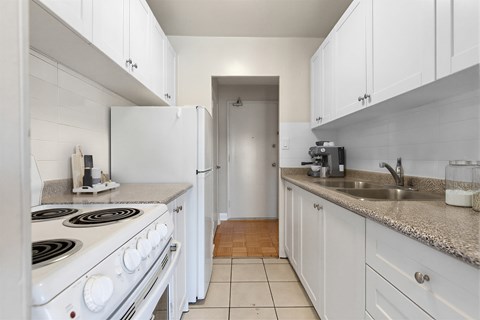 A kitchen with white appliances and cabinets.