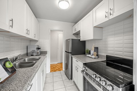 A kitchen with white cabinets and a stainless steel oven.