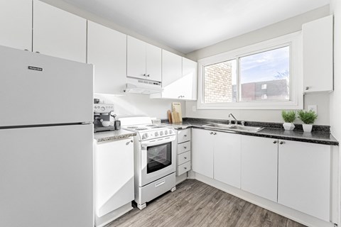 A modern kitchen with white appliances and cabinets.