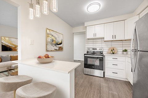 A modern kitchen with a white island and stainless steel appliances.