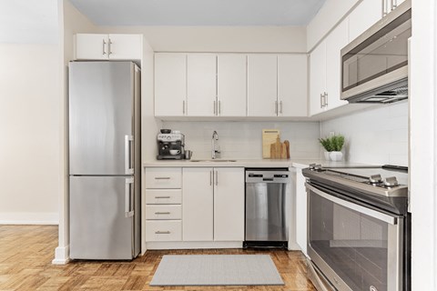 A modern kitchen with a refrigerator, oven, and cabinets.