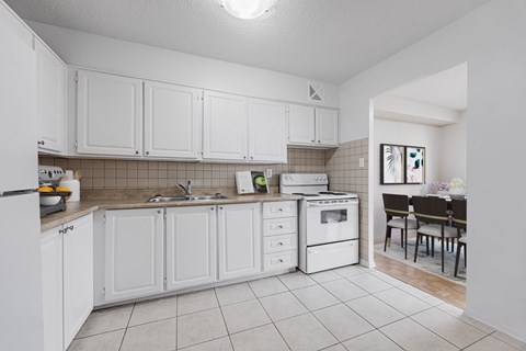 A kitchen with white cabinets and appliances.