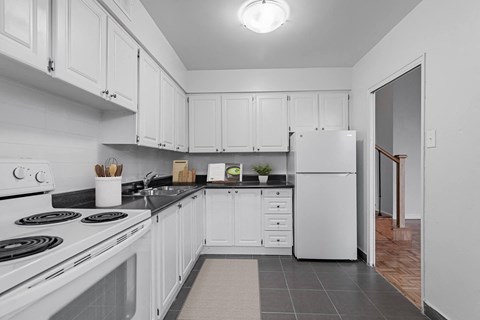 A kitchen with white cabinets and appliances.