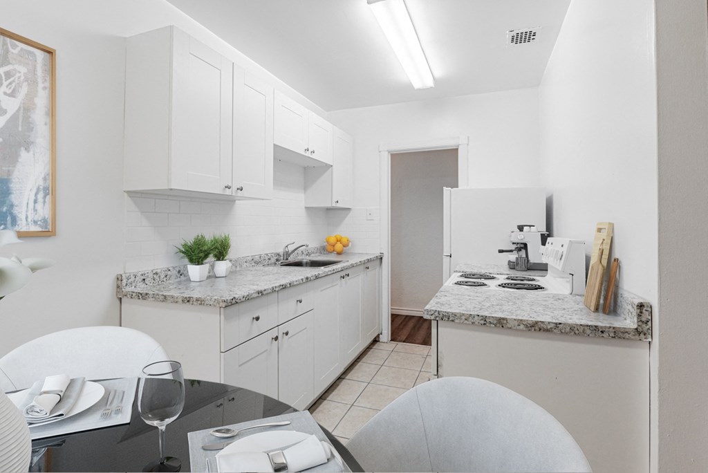 A kitchen with a table set for two.