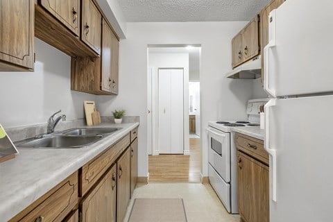 A kitchen with wooden cabinets and a white refrigerator.