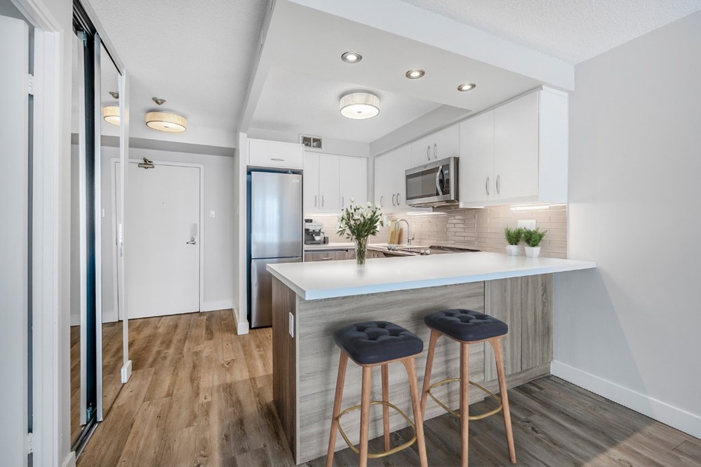 A kitchen with a bar stool and a counter.