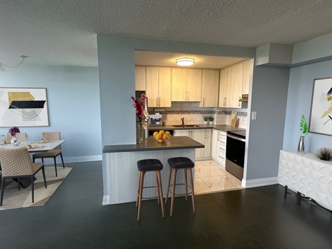 A kitchen with a table and chairs in front of it.