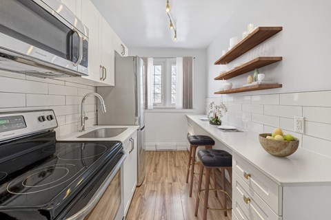 A modern kitchen with a black stove top oven and white cabinets.