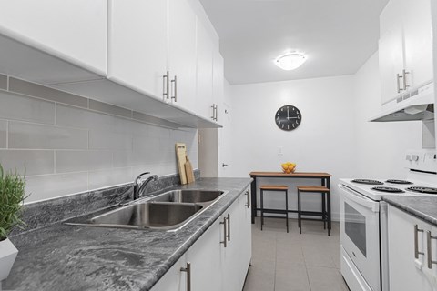 A kitchen with a sink, stove, and counter.