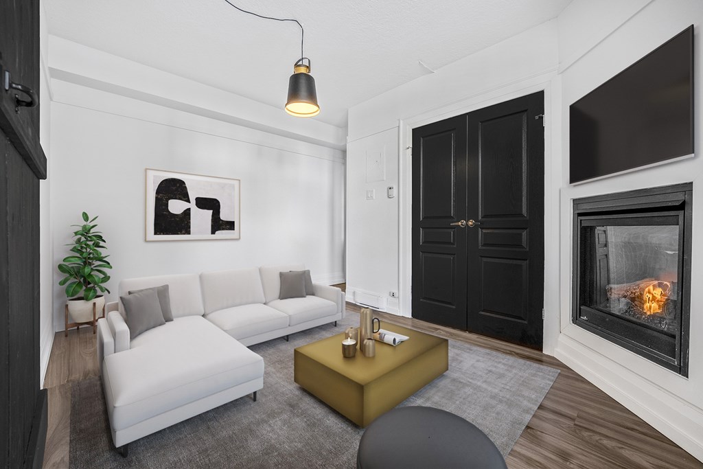 A modern living room with a grey sofa, a yellow coffee table, and a fireplace.