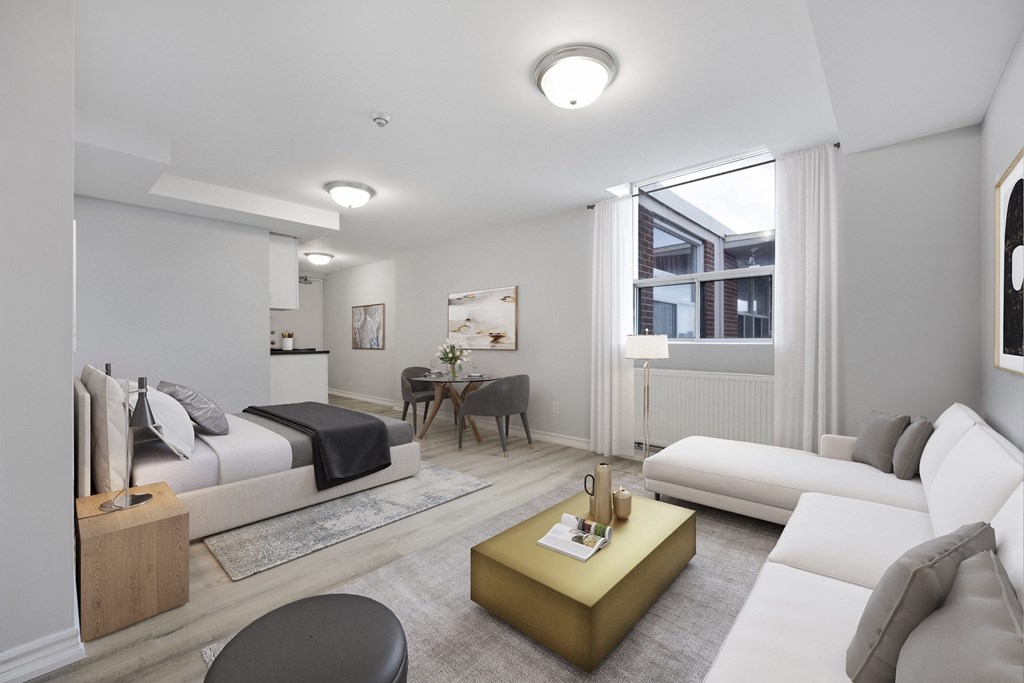 A modern living room with a white couch, a yellow coffee table, and a black chair.