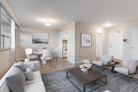 A living room with a white couch, a coffee table, and a painting on the wall.