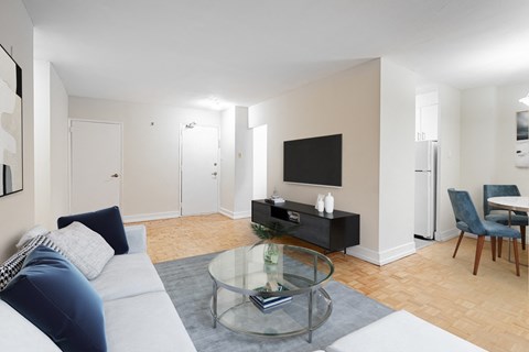 A living room with a glass coffee table and a white sofa.