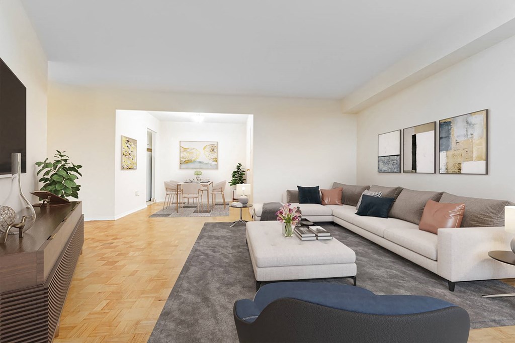 A modern living room with a white sofa, a grey coffee table, and a wooden floor.