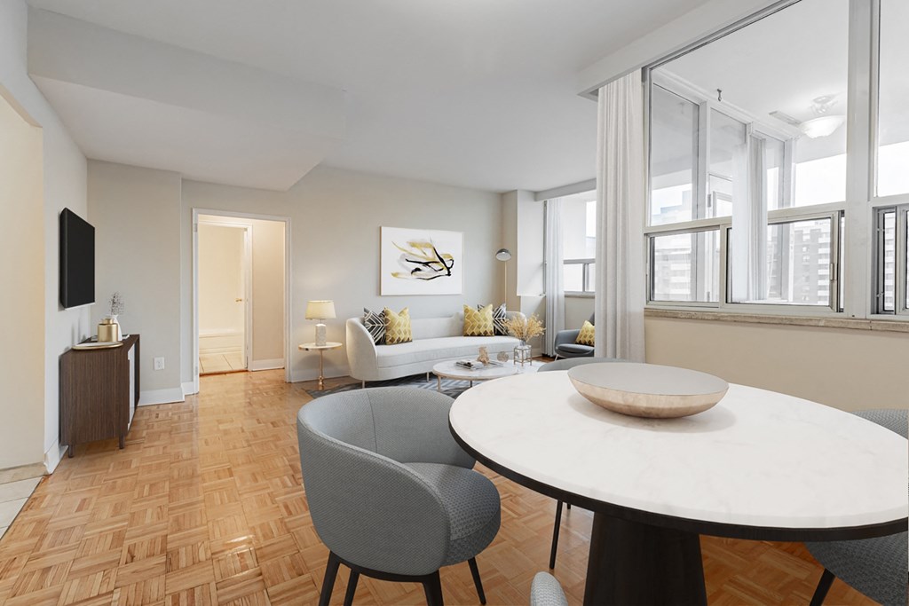 A modern dining room with a round table and grey chairs.