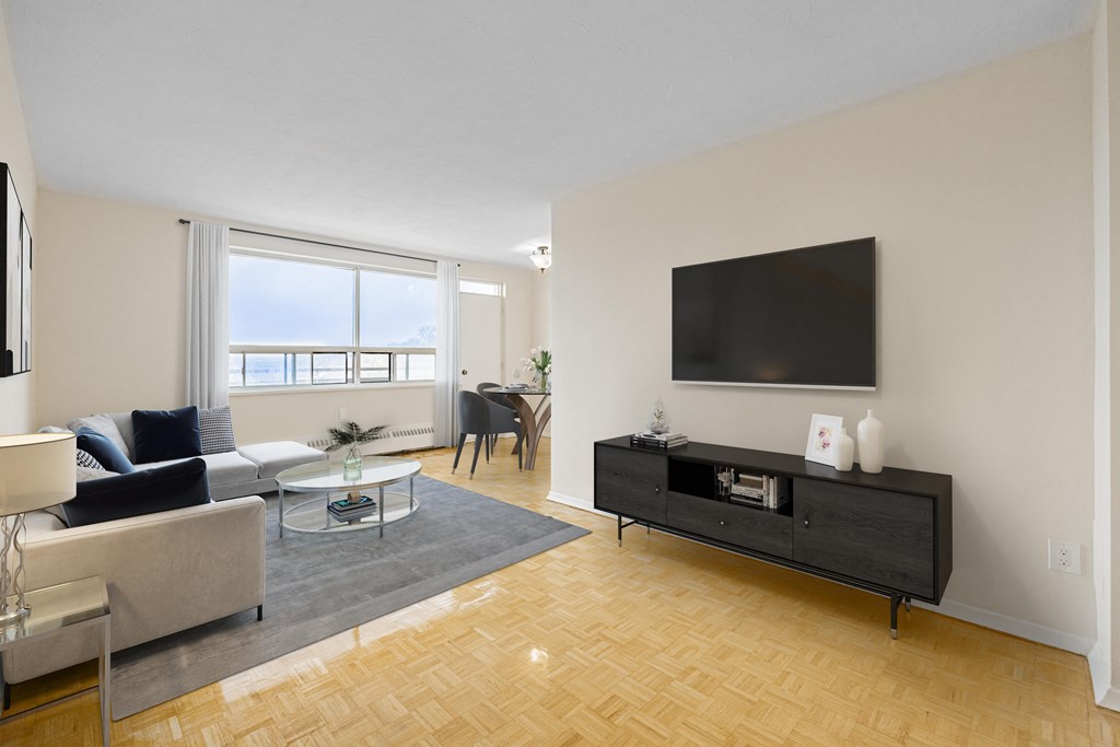 A living room with a grey sofa, a black cabinet, and a flat screen TV.