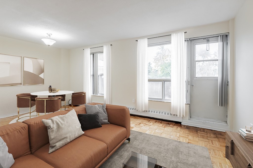 A living room with a brown couch and a grey rug.