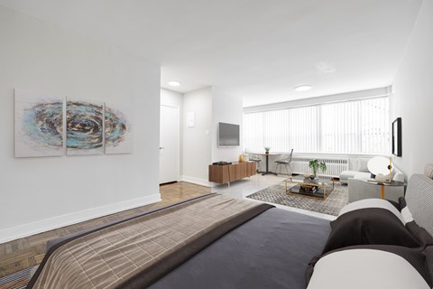 A modern bedroom with a large bed and a painting on the wall.