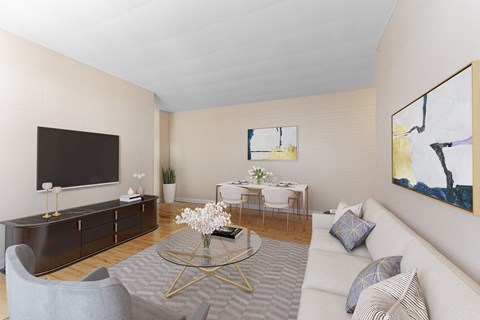 A living room with a grey couch, a coffee table, a television, and a painting on the wall.