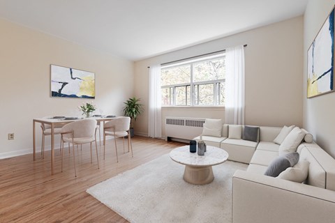 A living room with a white couch, a coffee table, and a dining table with chairs.