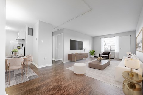 A modern living room with a dining area and a kitchen in the background.