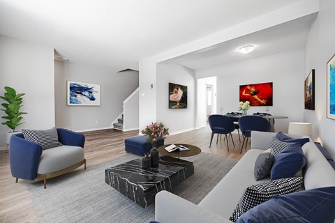 A living room with a blue chair and a grey couch.
