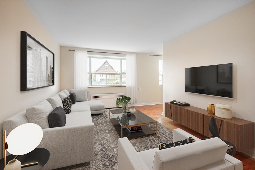 A living room with a grey couch, a black and white lamp, a coffee table, and a television.