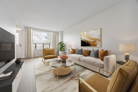 A modern living room with a grey sofa, a coffee table, and a large painting on the wall.