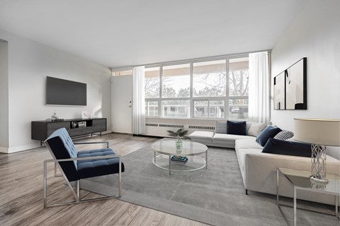 A modern living room with a blue chair and a glass coffee table.