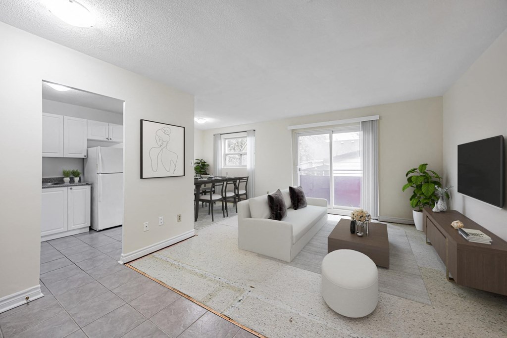 A living room with a white couch and a television on the wall.