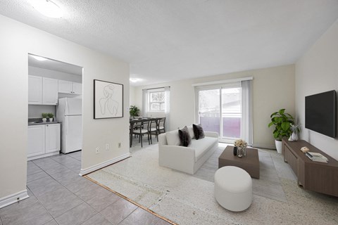 A living room with a white couch and a television on the wall.