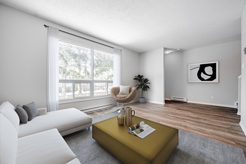 A living room with a white couch, a yellow coffee table, and a large window.